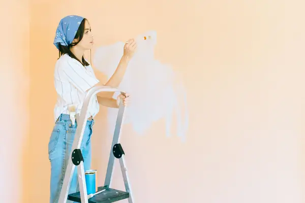 Interior painting in Dayton: painter on a stepladder rolling a wall